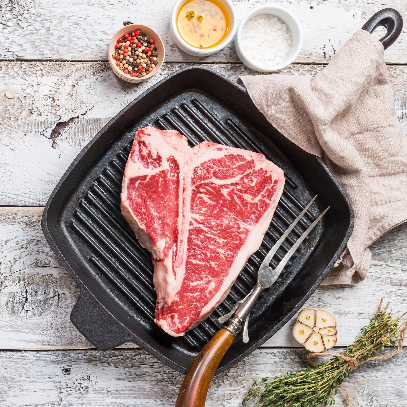 Succulent pulled pork on a wooden cutting board, showcasing tender, shredded meat with a crispy outer layer. A fork rests beside the meat, highlighting its juicy texture and rich seasoning.